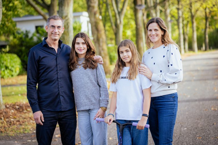 Gezin met twee kinderen dat samen ontspannen buiten staat – beeld voor het Weer een Blij Kind traject voor ouders van kinderen die niet worden gezien of begrepen in het schoolsysteem